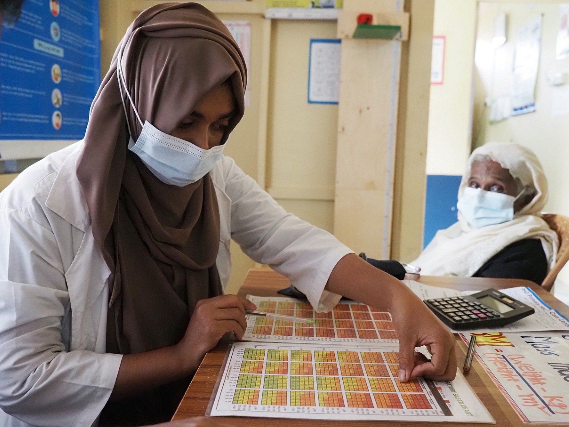 bangladesh-feature-story health worker sitting at desk with patient sitting
