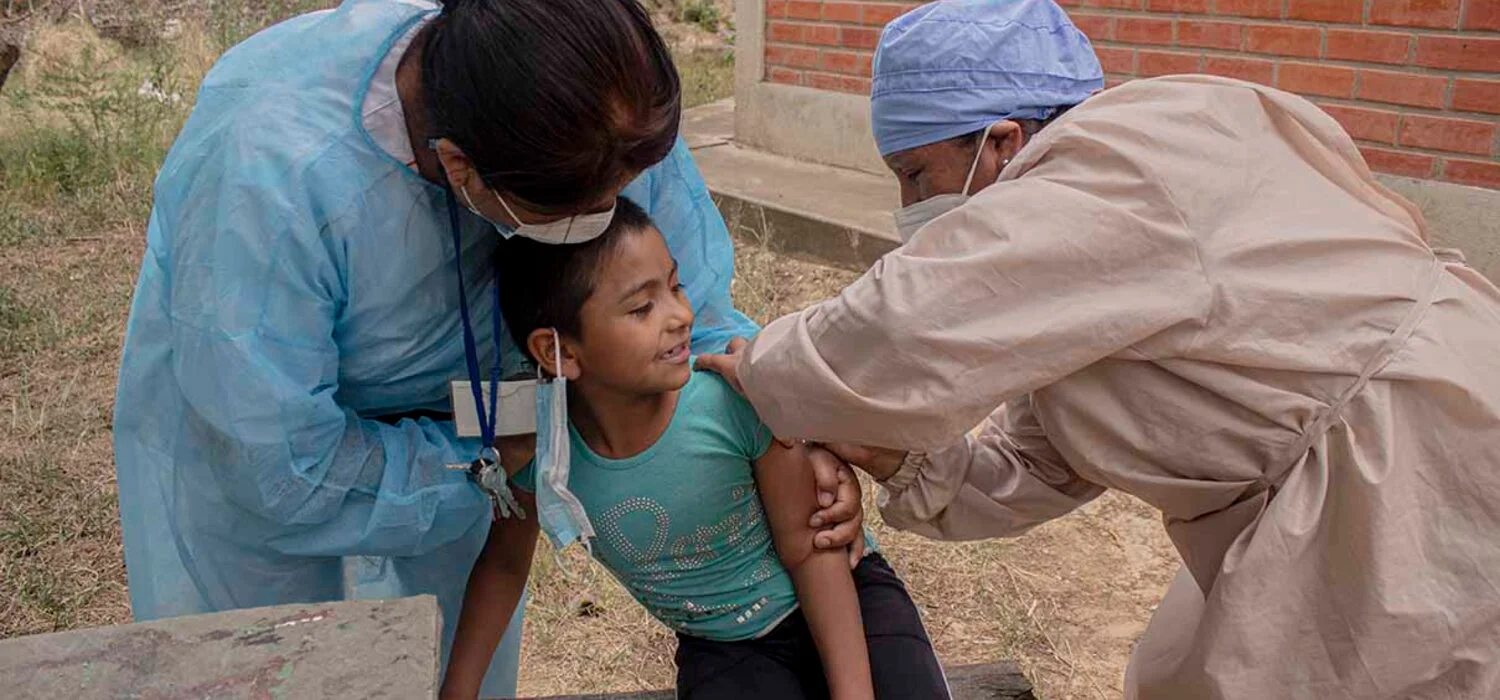 paho-vph_tarijabolivia_2 health worker giving vaccination to a young patient being held by another health worker