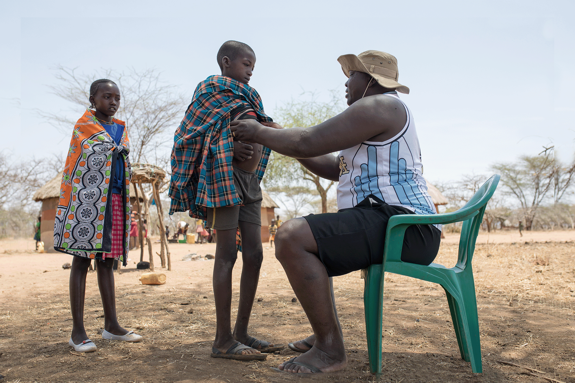 Community-health-mobilizer-examining-a-suspected-kala-azar-patient Ochieng Andrew, a community Health Mobilizer, examining Losur Emmanuel,a suspected Kala-azar patient in Lopedot Village in Amudat, Uganda.